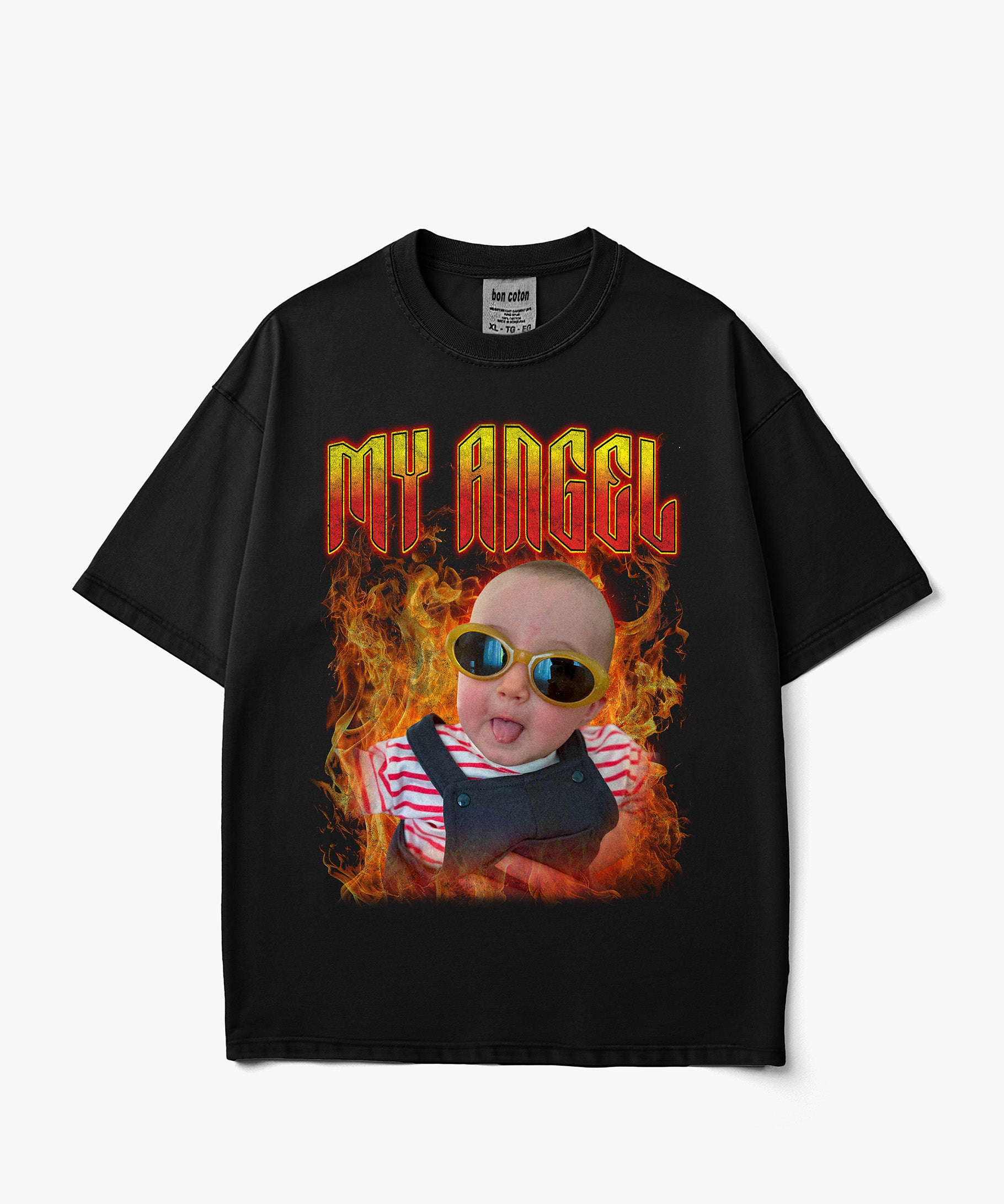 Image of A black short-sleeve custom bootleg t-shirt with a graphic print of a baby wearing sunglasses and overalls surrounded by flames, with the text 'MY ANGEL' in red and yellow. The shirt is displayed flat against a light gray background.